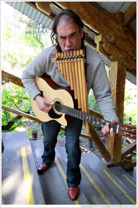 Musician playing pipes and guitar simultaneously, entertaining the funicular riders, Cerro San Crist?.