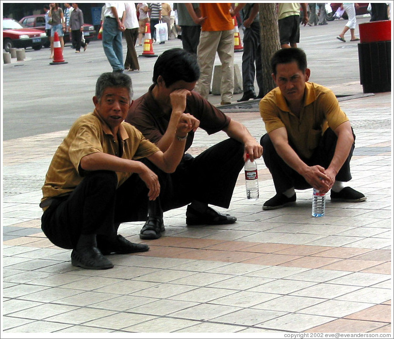Men squatting.  Wangfujing Ave.