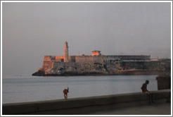 Morro Castle (Castillo de los Tres Reyes del Morro), with a dog standing on the Malec&oacute;n wall, at dusk.