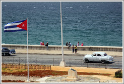 Cuban flag and a white car on the Malec&oacute;n.
