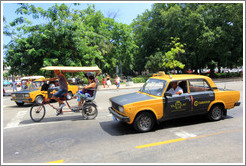 Bicycle taxi and black and white auto taxi, corner of Paseo del Prado and Calle Obrapia.