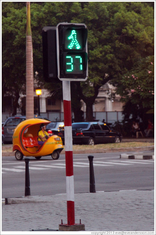 Walk sign with a countdown of remaining seconds, and a Coco taxi, Paseo del Prado.