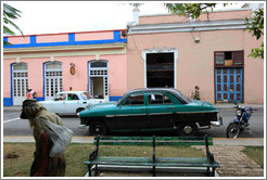 Homeless man and dark green car, near Parque de la Libertad (Liberty Park).