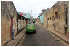 Street with green car.