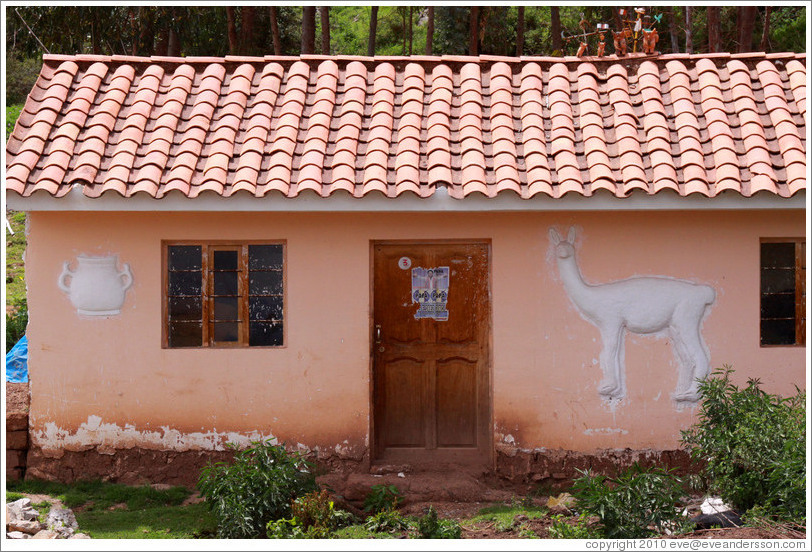 House near the Puca Pucara ruins, with a relief of a jar and an alpaca.