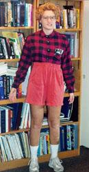 nerdy female with orange shorts, plaid red shirt, and white socks and shoes