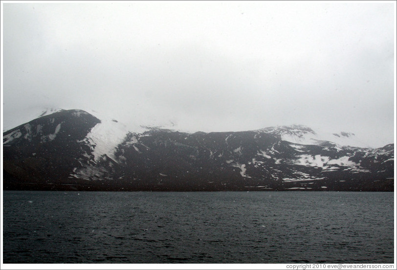 The snow-covered volcanic mountains of Deception Island.
