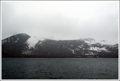 The snow-covered volcanic mountains of Deception Island.