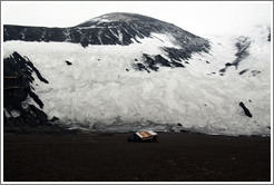 Building remains in front of a snowy, volcanic mountain, Whaler's Bay.