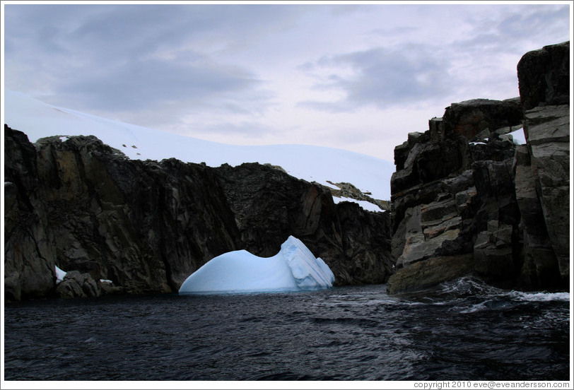 Blue iceberg against the backdrop of one of the Melchior Islands.