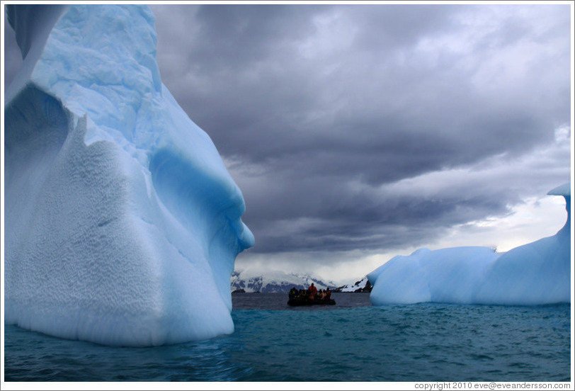 Zodiac among blue icebergs.