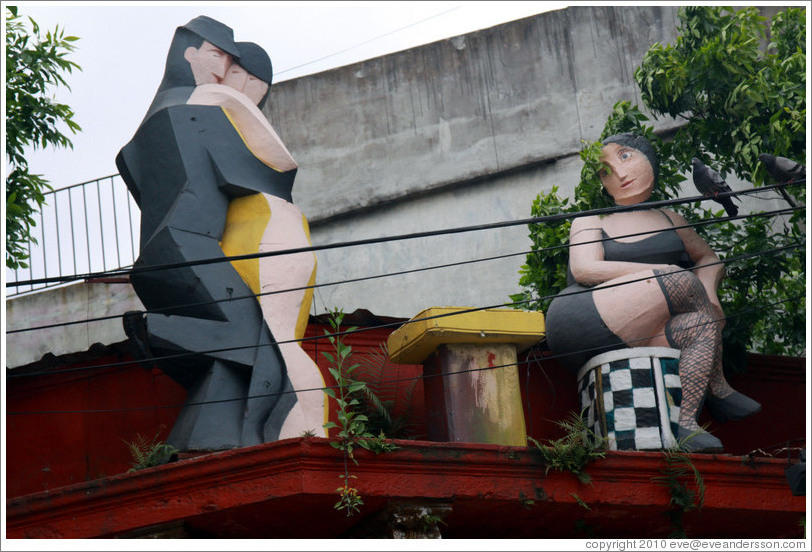 Sculptures on the roof of a building, depicting tango dancers and a longing spectator. Gral. Gregorio Ar? de Lamadrid, La Boca.