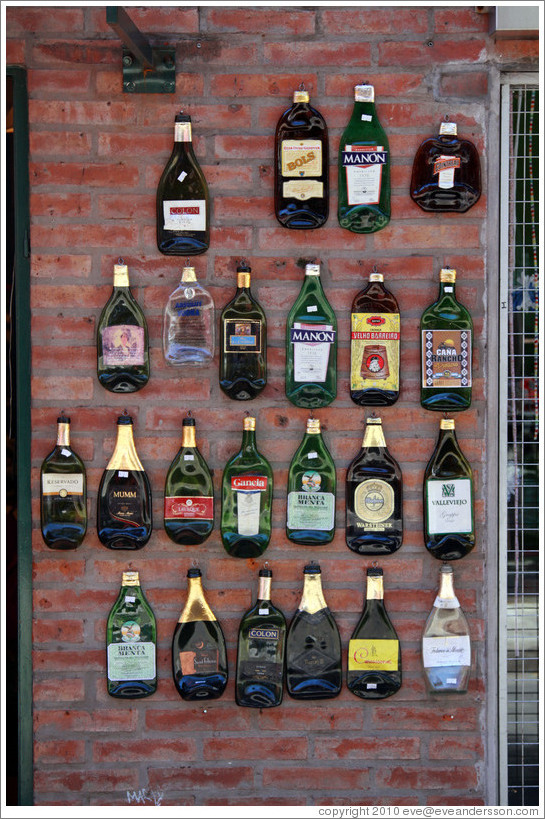 Flattened bottles on a wall. Russel, Palermo Soho.