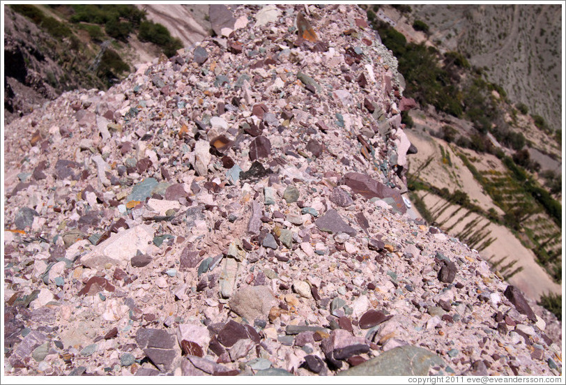 Natural stones of many colors embedded in a hillside.