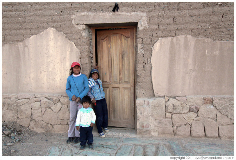 Three kids in a doorway.