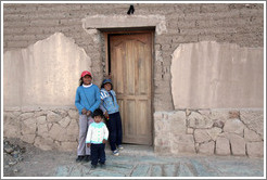 Three kids in a doorway.