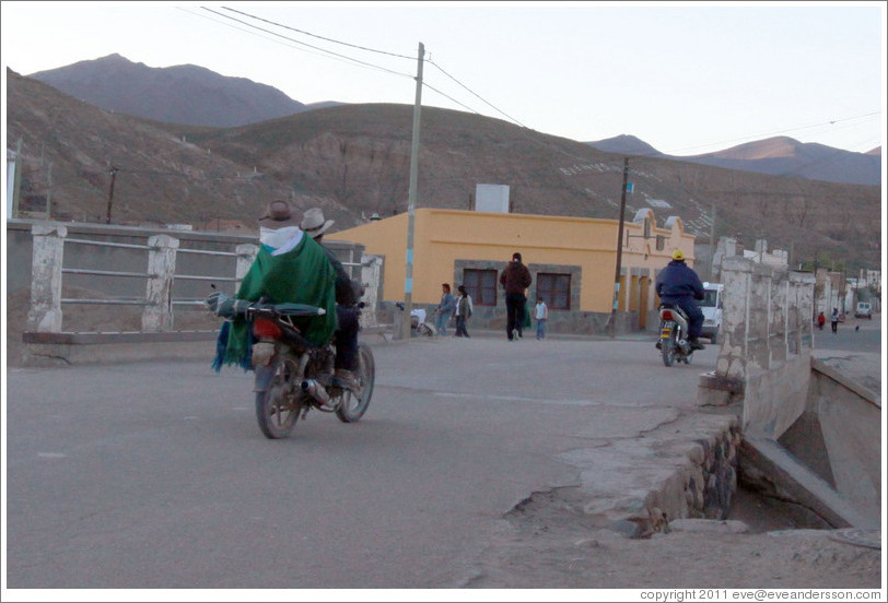 Motorcyclists crossing a bridge.