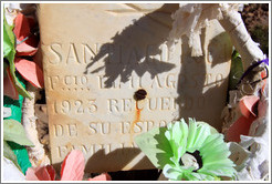 Headstone and plastic flowers for Santiago Ruca who passed away in August 1923, in a small miners' cemetery near La Polvorilla viaduct.