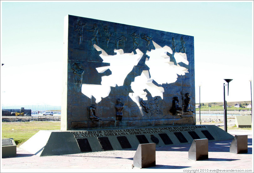 Malvinas memorial which reads, "El pueblo de Ushuaia a quienes ... con su sangre regaron las raices de nuestra soberania sobre Malvinas ... volveremos!!!" Translation: "The town of Ushuaia who ... with their blood watered the roots of our sovereignty over Malvinas ... we will return!!!"