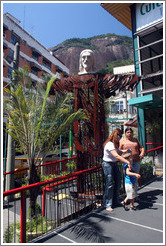 Small model of Cristo Redentor (Christ the Redeemer) with tourists at the bottom of Corcovado Mountain.