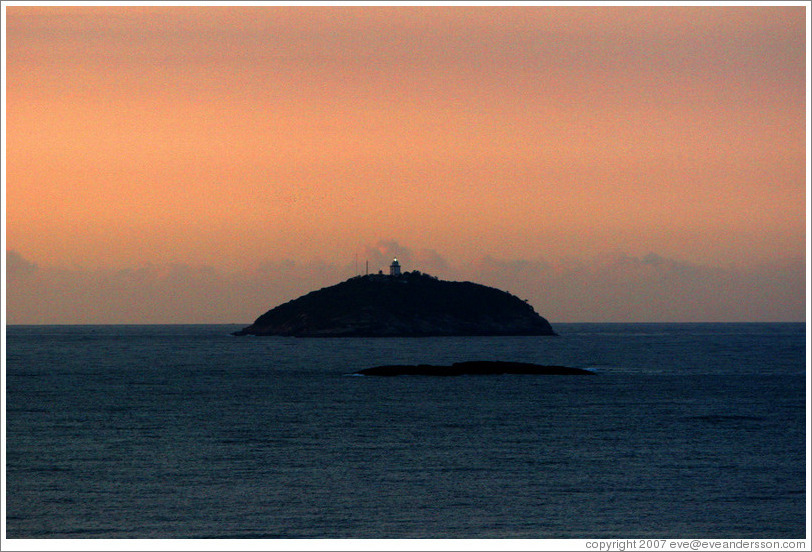 Island with lighthouse at sunrise, viewed from Ipanema.