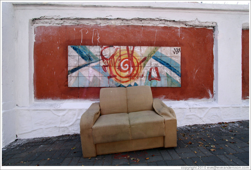 Sofa in front of artwork on the wall surrounding the Cemit?o S?Paulo.