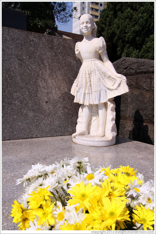 Sculpture of a girl and flowers on a tomb.  Cemit?o S?Paulo.