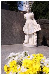 Sculpture of a girl and flowers on a tomb.  Cemit?o S?Paulo.