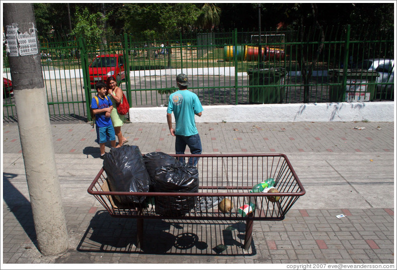 S&atilde;o Paulo street.  Pedestrians and garbage receptacle.