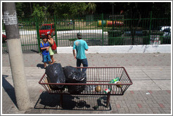 S&atilde;o Paulo street.  Pedestrians and garbage receptacle.