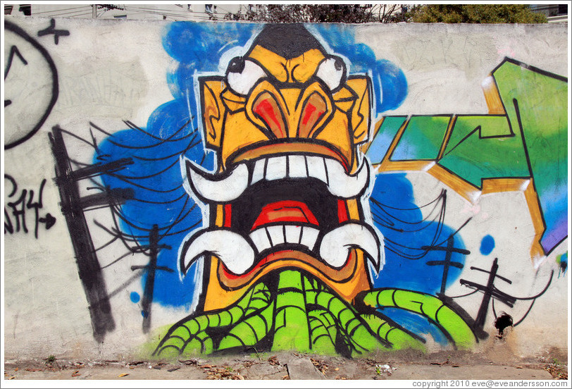 Graffiti: creature with pointed teeth and green tubes.  Av. H?o Pellegrino at Rua Marcos Lopes.