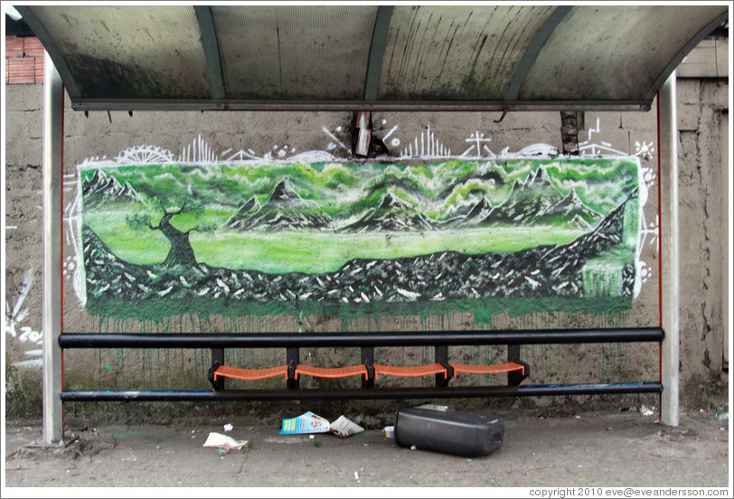 Graffiti at a bus stop: green mountains and trees.  Av. Pres. Juscelino Kubitschek at Rua Dr. Renato Paes de Barros.