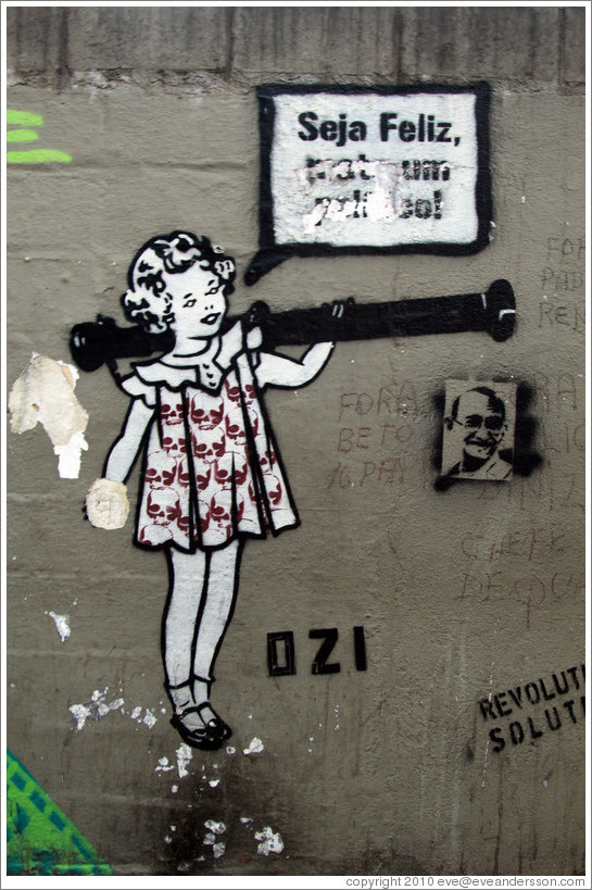 Graffiti: girl with skulls on her dress saying "Seja Feliz".  Created by graffiti artist Ozi.  Av. Brg. Lu?Ant? at Pra?Dom Gast?Liberal Pinto.