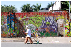 Graffiti: man with purple flames.  Woman walking in front.  Rua Nova Cidade.