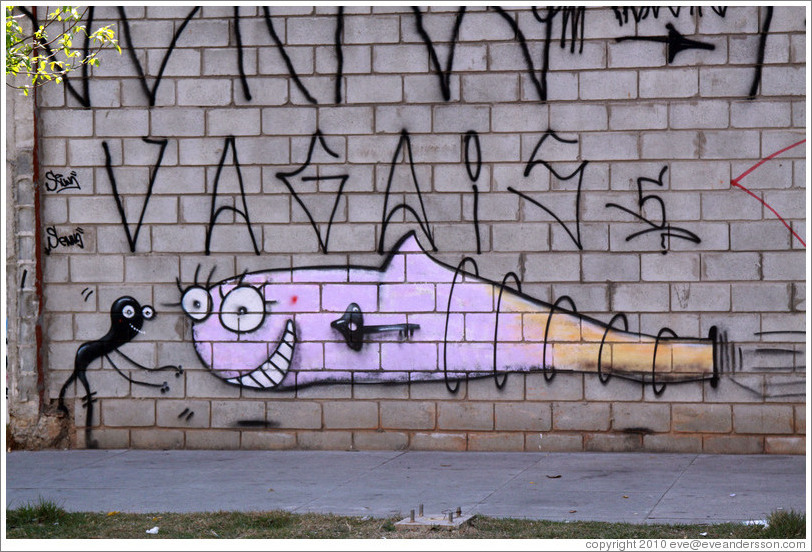 Graffiti: pink fish in love with a black squiggle.  Rua Olimp?as.