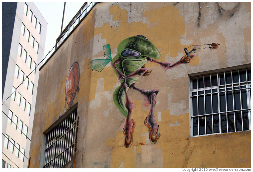 Graffiti: flying green insect with slingshot.  Villa Magdalenda neighborhood.  Rua Belmiro Braga and Rua Cardeal Arcoverde.
