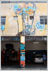 Graffiti over an auto mechanic: man with scissors in a hot air balloon.  Villa Magdalenda neighborhood.  Rua Belmiro Braga and Rua Cardeal Arcoverde.