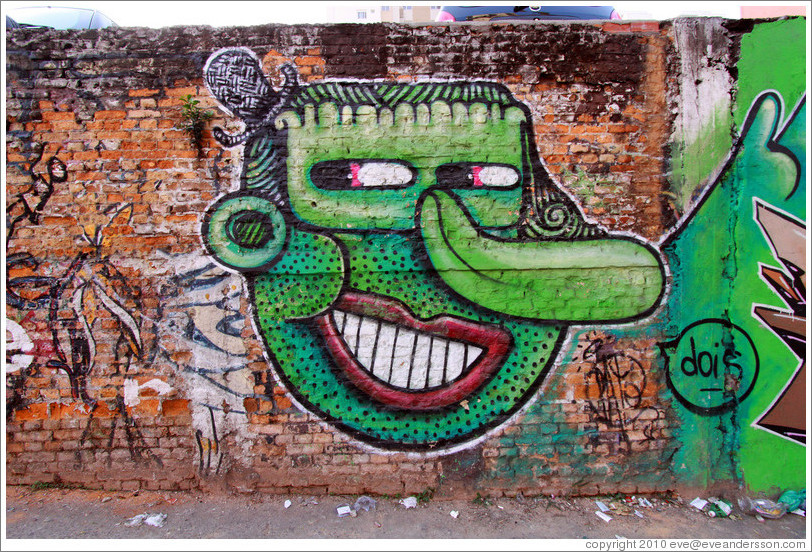 Graffiti: Frankenstein-like face with large nose and small top hat.  Villa Magdalenda neighborhood.  Rua Cardeal Arcoverde.