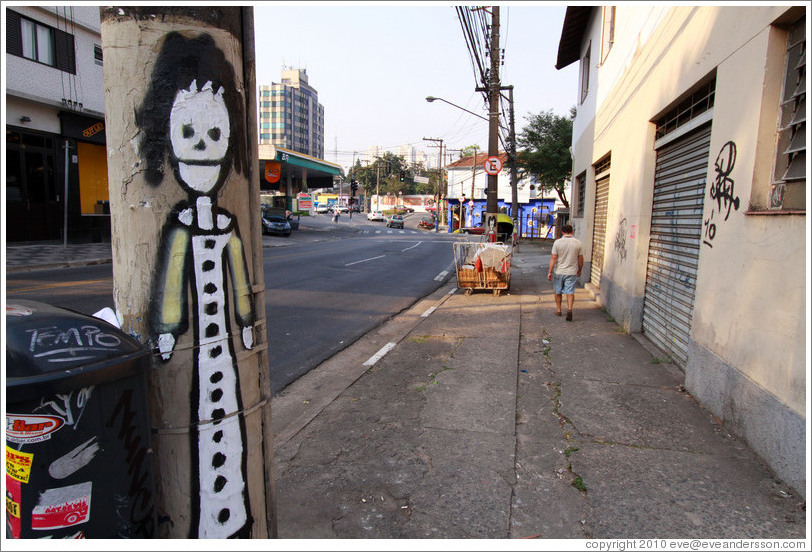 Graffiti: woman wearing a dress on lamppost.  Villa Magdalenda neighborhood.  Rua Padre Jo?Gon?ves and Rua In?o Pereira da Rocha.