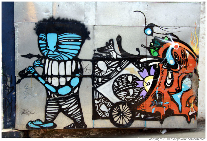 Graffiti: blue man pulling a cart.  Villa Magdalenda neighborhood.  Rua Padre Jo?Gon?ves near Rua Fradique Coutinho.
