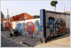 Man pulling a cart near graffiti of a man pulling a cart.  Villa Magdalenda neighborhood.  Rua Padre Jo?Gon?ves near Rua Fradique Coutinho.