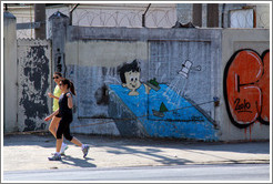 Graffiti: kid in a bathtub with boats. Two women walking past.  Rua Manuel da N?ga at Av. Mal. Est?o Albuquerque Lima.