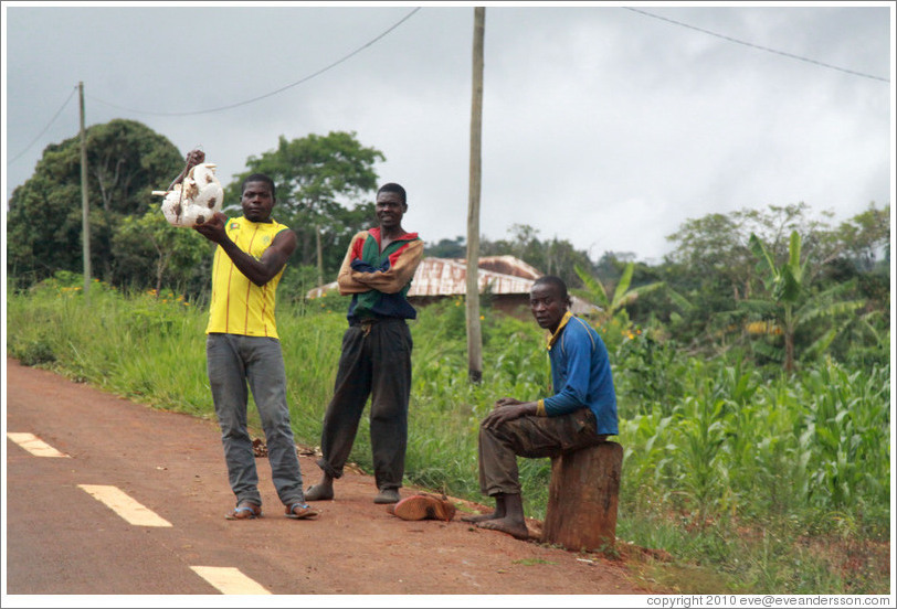 Three men selling goods at the side of the road, near the town of Bangangt