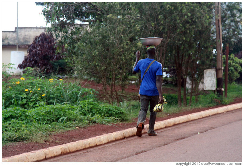 Man carrying a bowl on his head.