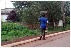 Man carrying a bowl on his head.