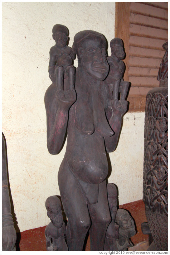 Wood carving of a woman with children.