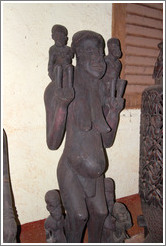 Wood carving of a woman with children.