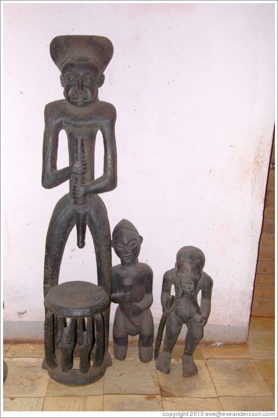 Chair with a wood carving of a man, and two wood carvings of smaller figures.