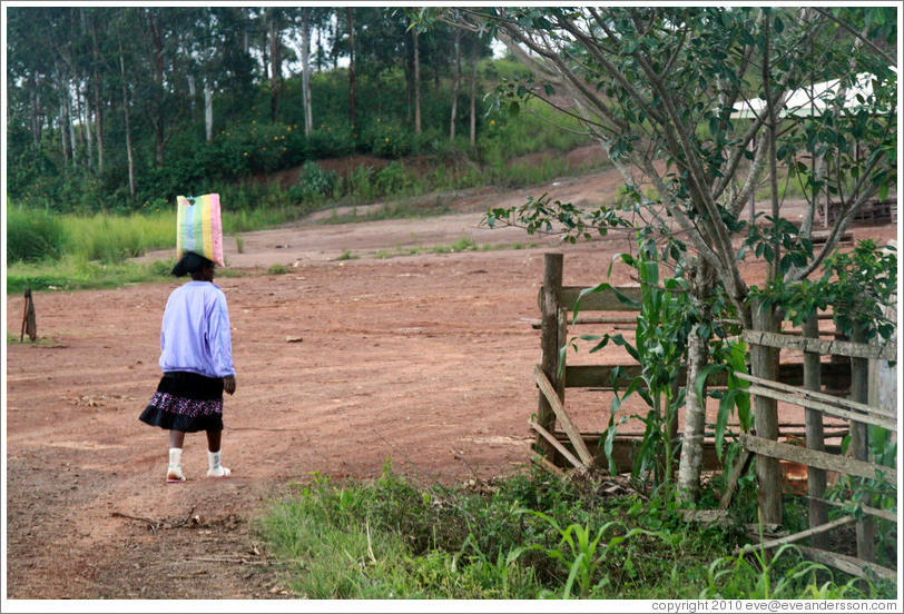 Girl carrying a bag on her head.