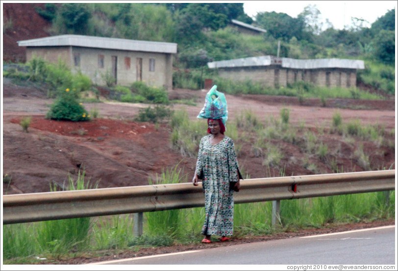 Woman carrying a bag on her head.